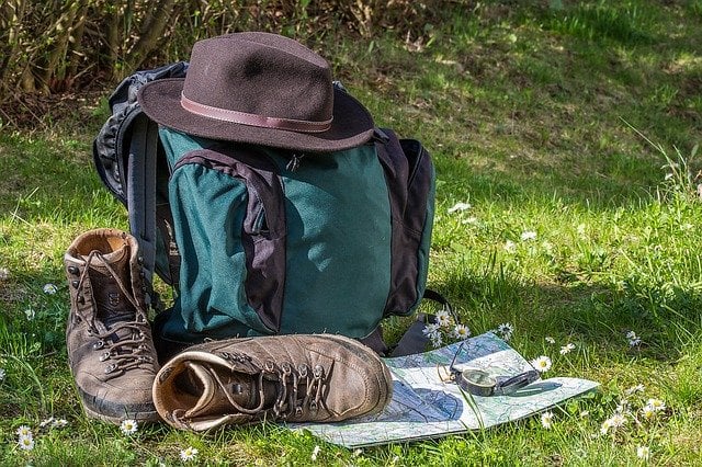 Regalo per amanti del trekking, scarponi, zaino, bussola e mappa su prato