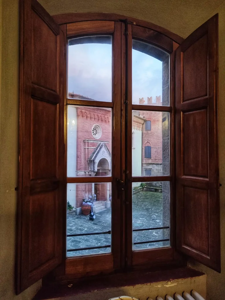 dormire in un castello in toscana la vista sulla chiesa e sul chiostro interno dalla finestra della mia camera